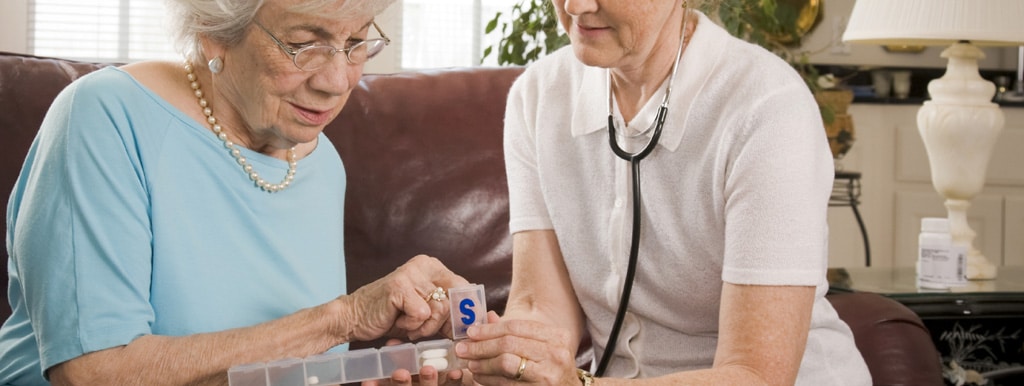 A carer helping a lady with her medication