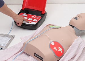 Picture of an Automated External Defibrillator being used in a training room